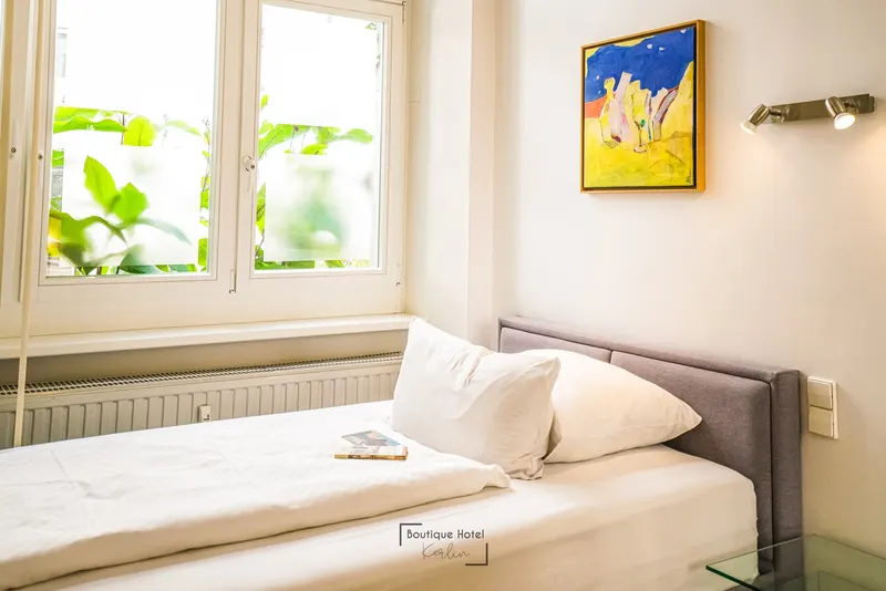 Ebenerdiges Einzelzimmer im Erdgeschoss mit Bett unter dem Fenster